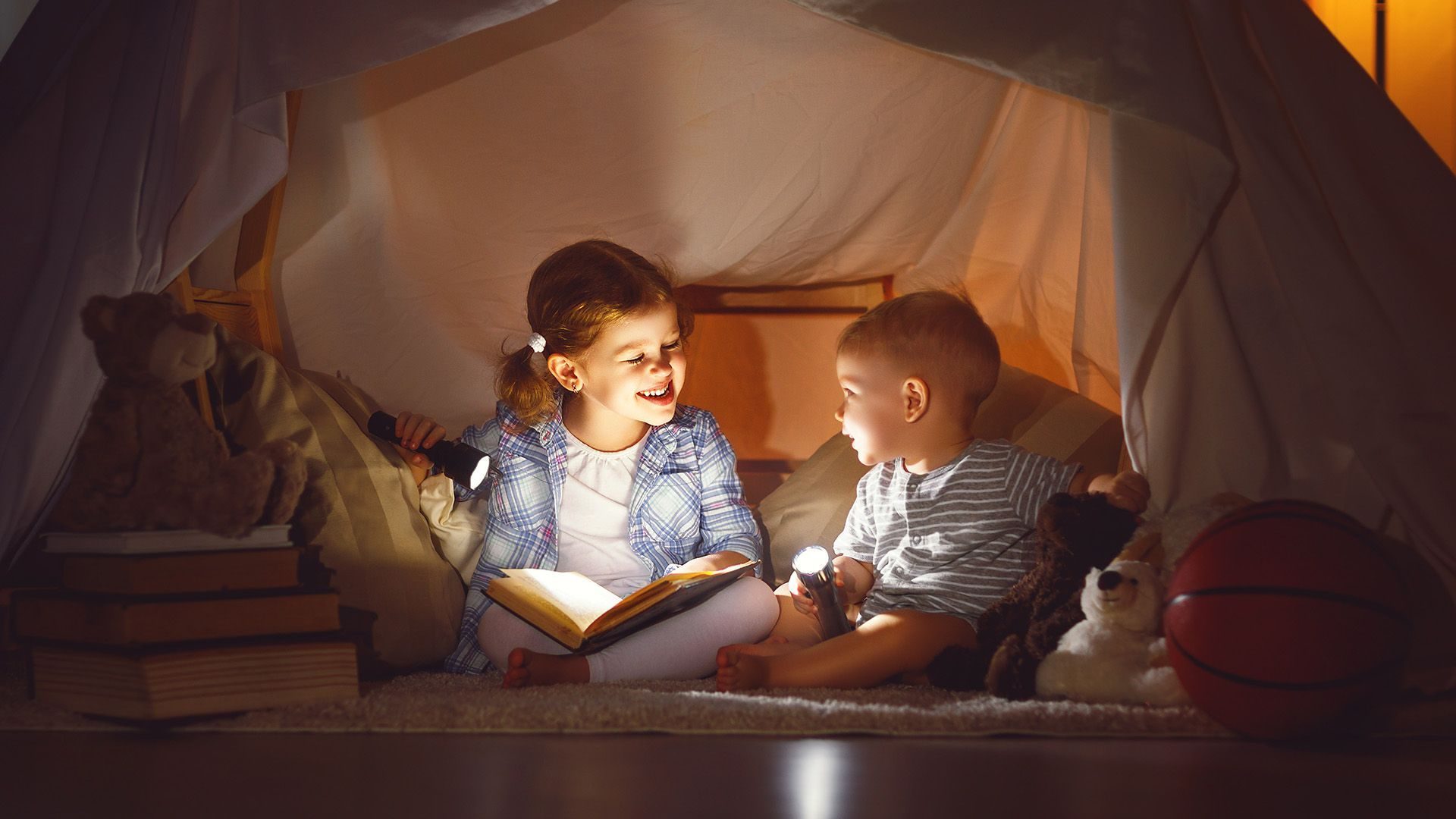 Kinderen spelen in een tent gemaakt van dekens - thuiswerken - kinderactiviteiten