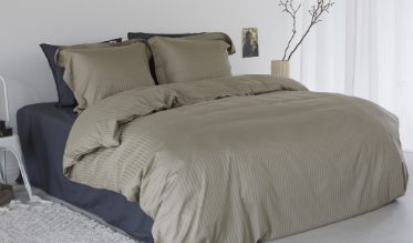 Een effen dekbedovertrek creëert een rustgevende sfeer in de slaapkamer.